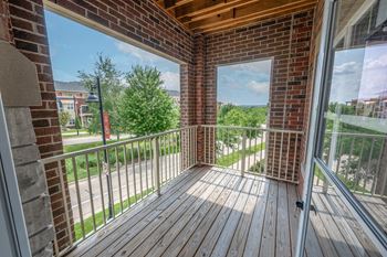 a balcony with a brick wall and a wooden deck